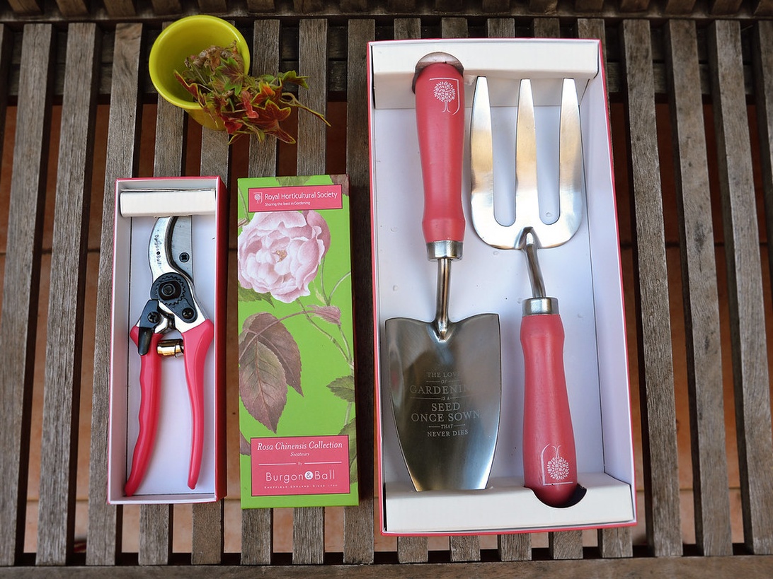 Nya trädgårdsverktyg i förpackning, inklusive en sekatör och ett set med handspade och kratta.